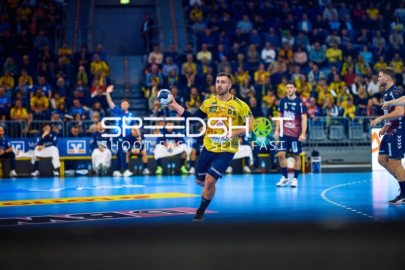 Ein Spieler der Rhein Neckar Löwen ist im Angriff und dribbelt den Ball.