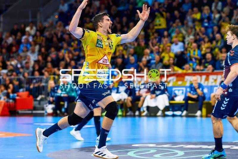 Ein Spieler der Rhein Neckar Löwen jubelt mit erhobenen Armen.