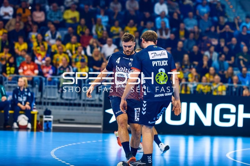 Zwei Spieler von SG Flensburg Handewitt stehen auf dem Spielfeld.