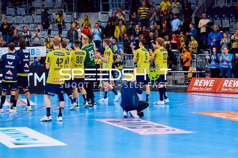 Spieler von Rhein Neckar Löwen auf dem Spielfeld, einige stehen und einige sind in Bewegung.