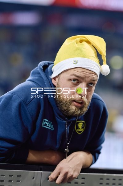 Ein Spieler in einem gelben Weihnachtsmannhut lehnt sich über die Bande.