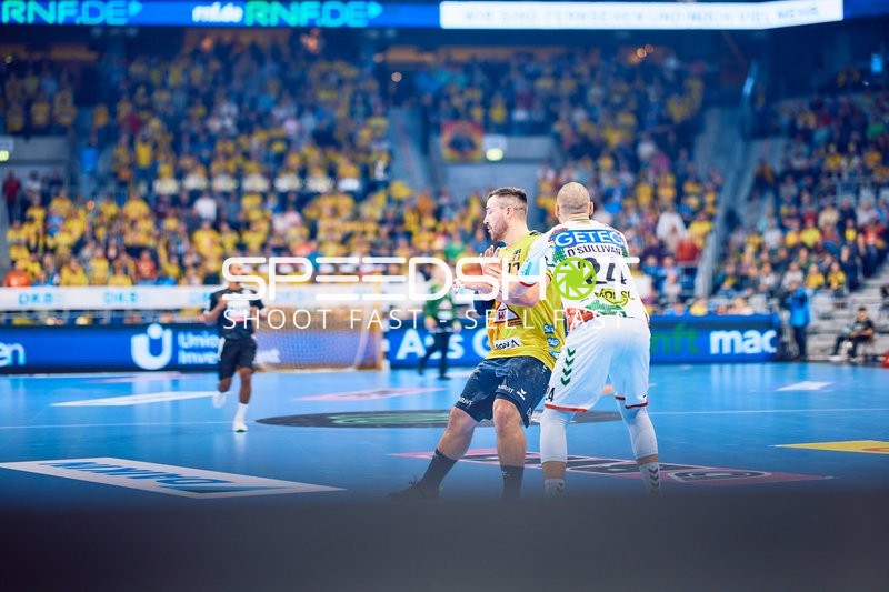 Ein Spieler von SC Magdeburg blockt einen Spieler der Rhein Neckar Löwen.