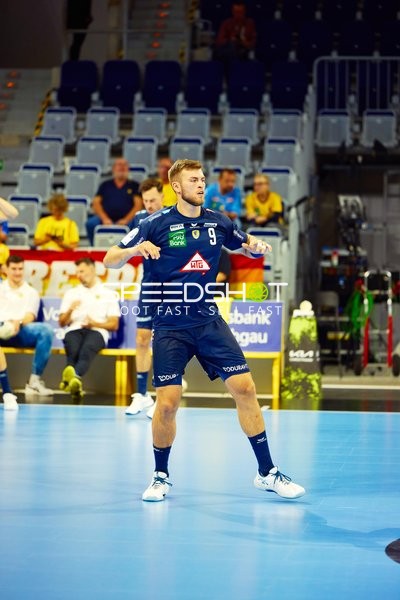 Spieler in Aktion während eines Handballspiels.