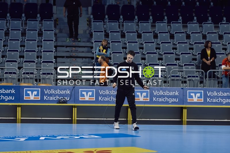 Ein Trainer bereitet das Spielfeld für ein Handballspiel vor.