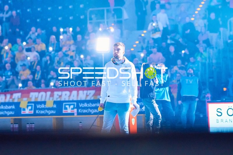 Zuschauer im Stadion beobachten eine Person auf dem Spielfeld.