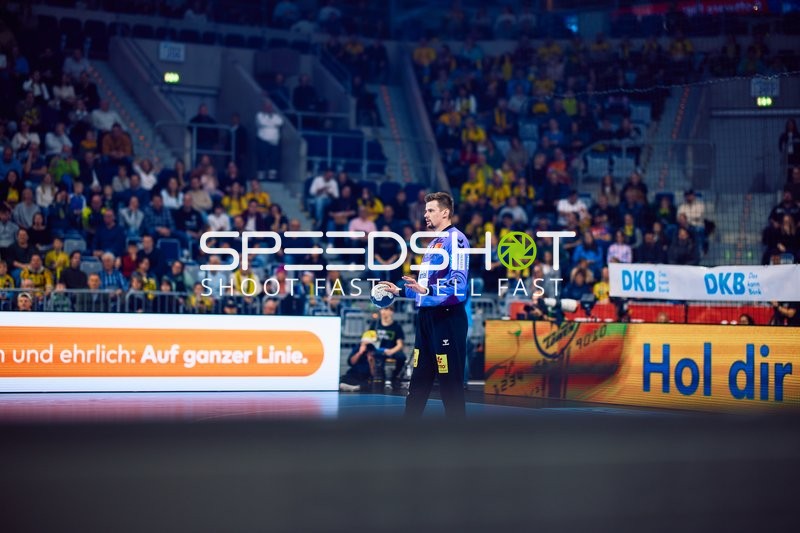 Ein Torhüter steht auf dem Spielfeld und beobachtet das Spielgeschehen.