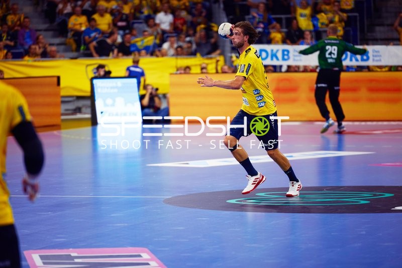 Ein Spieler von Rhein Neckar Löwen springt mit dem Ball in Richtung Tor.