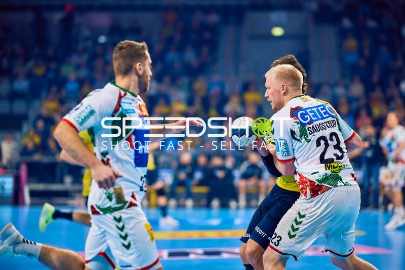 Ein Spieler von SC Magdeburg mit der Nummer 23 führt den Ball gegen die Verteidigung der Rhein Neckar Löwen.