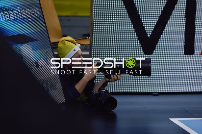 Ein Fotograf liegt am Spielfeldrand und fotografiert das Spiel.