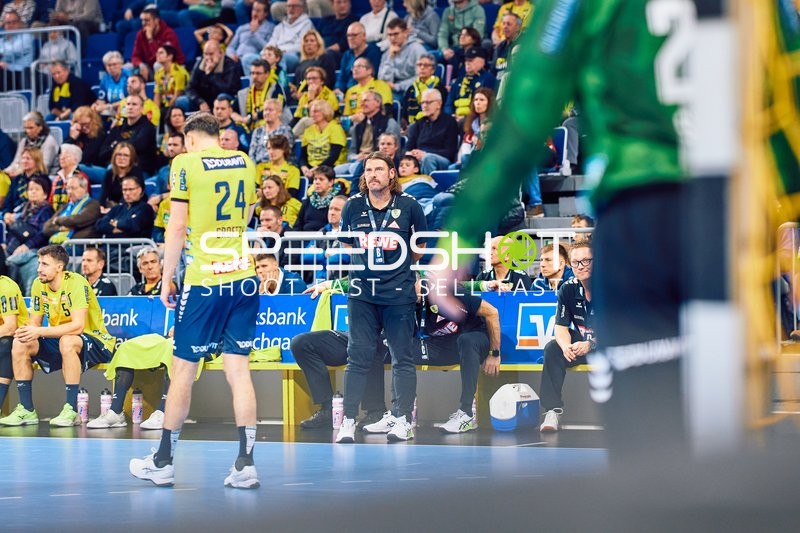 Trainer Sebastian Hinze gibt Anweisungen an Ivan Martinović auf dem Spielfeld.