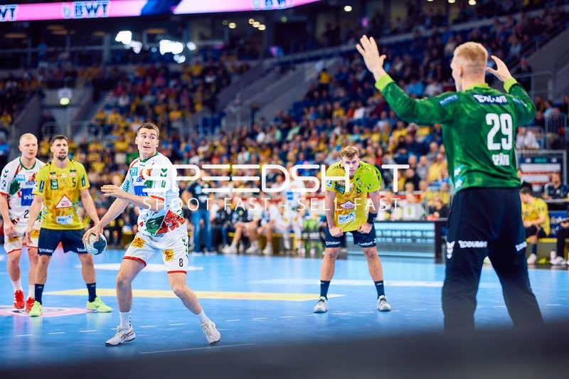 Ein Spieler des SC Magdeburg bereitet sich darauf vor, den Ball im Angriffsspiel zu passen, während der Torwart der Rhein Neckar Löwen sich darauf einstellt.