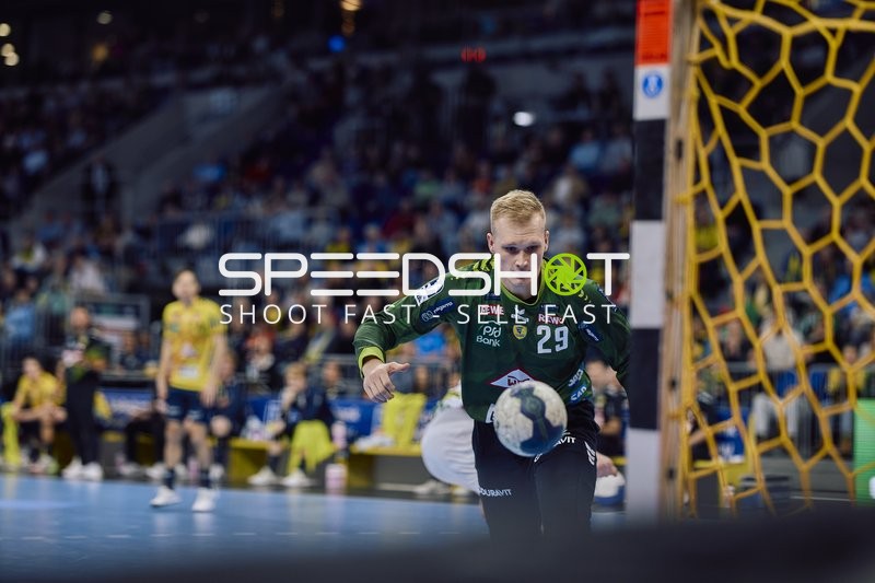 Ein Spieler des SC Magdeburg hält den Ball im Spiel.