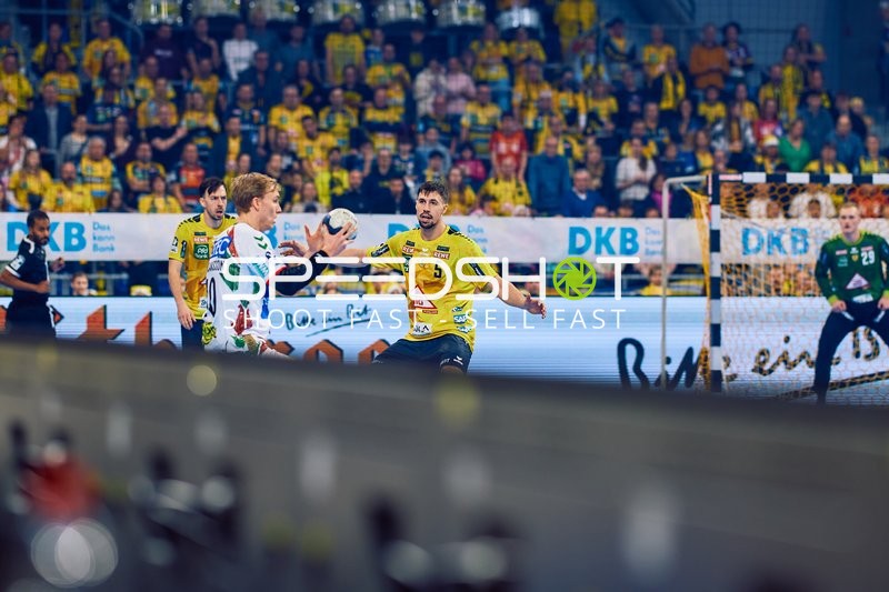 Ein Spieler von Rhein Neckar Löwen verteidigt gegen einen Spieler von SC Magdeburg.