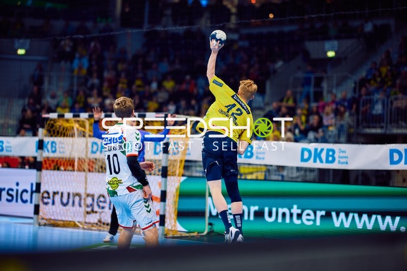 Ein Spieler von Rhein Neckar Löwen springt in die Luft und hält den Ball.