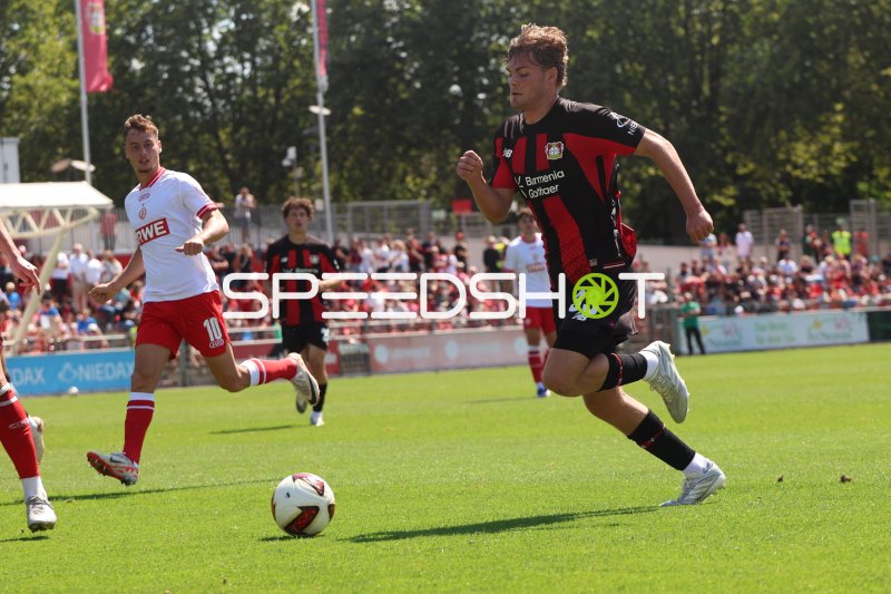 Tobias Kraulich (#33; Bayer 04 Leverkusen) läuft mit Ball vor Marvin Obuz (#10; Rot-Weiss Essen)