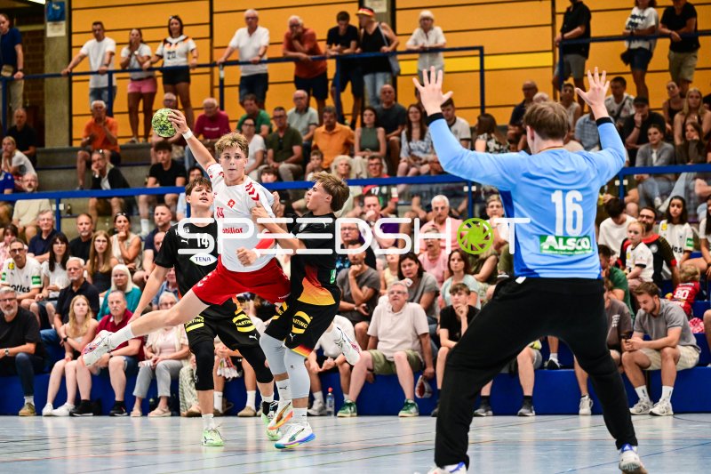 Schweizer Angreifer (#19) beim Sprungwurf gegen deutschen Torwart (#16)