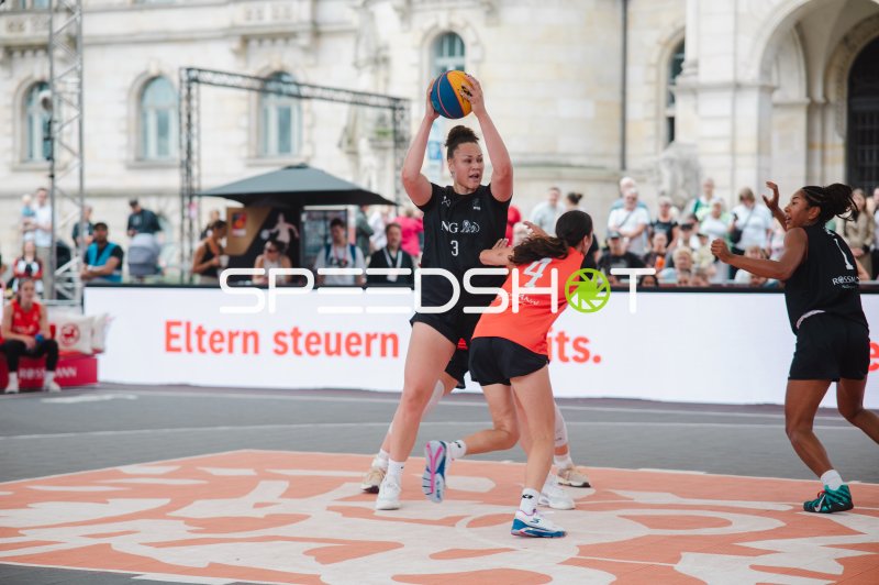 3x3-Basketball-Spielerin (#3) hält Ball hoch gegen Gegnerin (#4) in Hannover