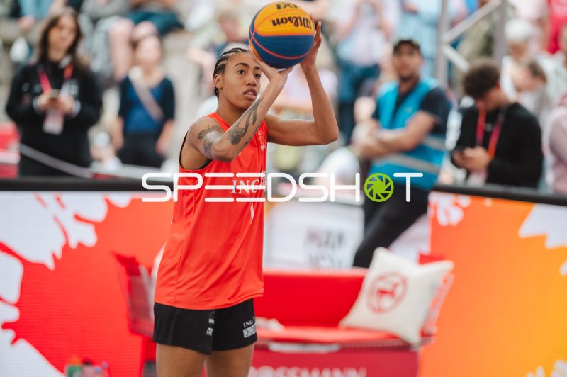 Spielerin im orangenen Trikot beim Wurfansatz im 3x3-Basketball
