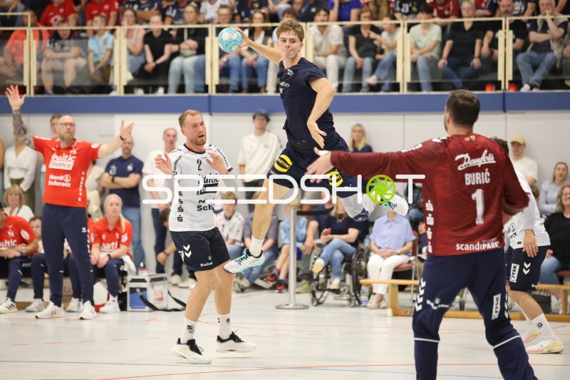 Skanderborg-Spieler springt zum Wurf gegen Benjamin Buric (#1; SG Flensburg Handewitt)
