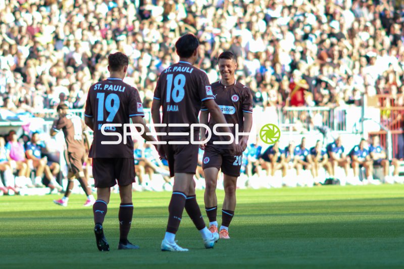 Mathias Rasmussen (#20; FC St. Pauli) lächelt im Gespräch mit Teamkollegen