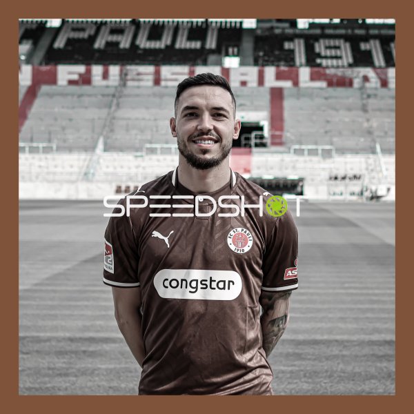 FC St. Pauli Spieler posiert im Trikot vor der Stadionkulisse