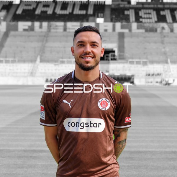 FC St. Pauli Spieler posiert im Trikot vor der Tribüne