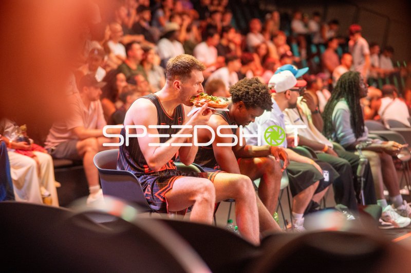 Basketballspieler isst Pizza in der Pause vor vollem Publikum in Ulm