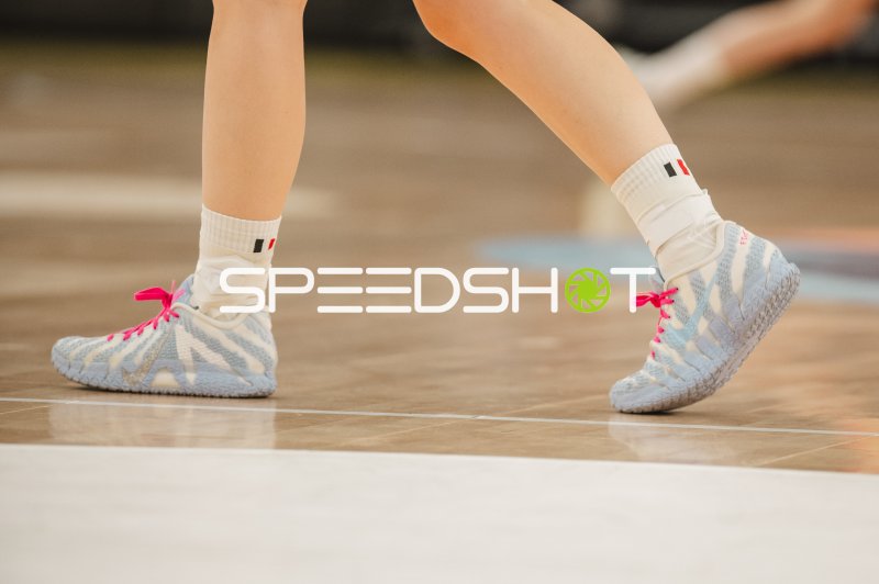Detailaufnahme: Handballschuhe mit pinken Schnürsenkeln auf dem Parkett