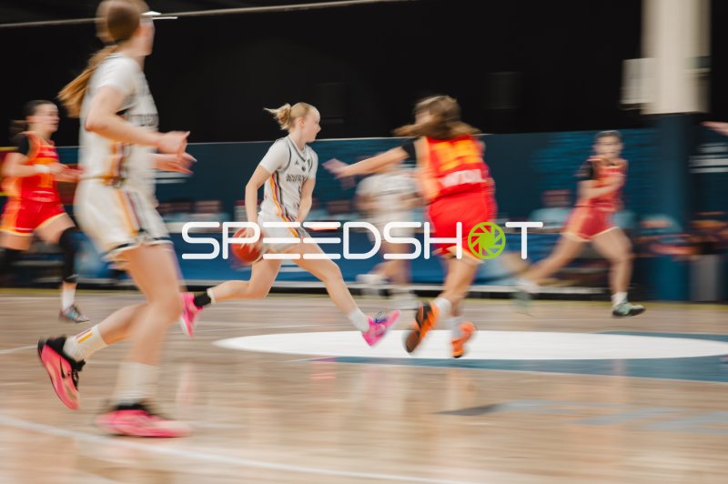 Spielerin im weißen Trikot treibt den Ball durch die gegnerische Abwehr