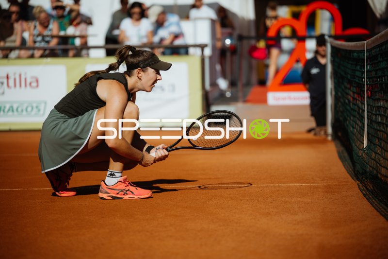 Tennisspielerin in konzentrierter Grundstellung am Netz auf Sand