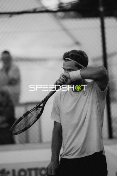 Tennisspieler wischt sich mit dem Handgelenk das Gesicht
