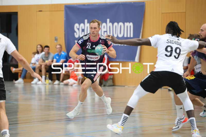Marian Michalczik (#22; TSV Hannover Burgdorf) im Angriff gegen Mouhamadou Sidibe (#99; PAUC Handball)