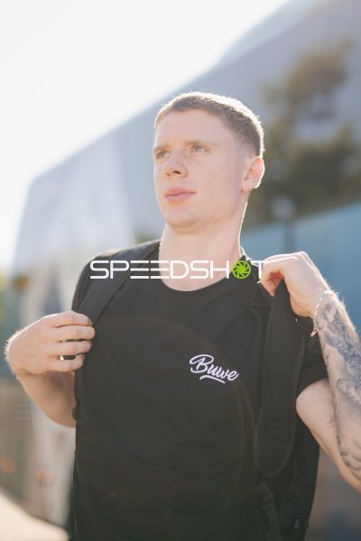 Junger Mann mit Rucksack und Tattoos im Gegenlicht
