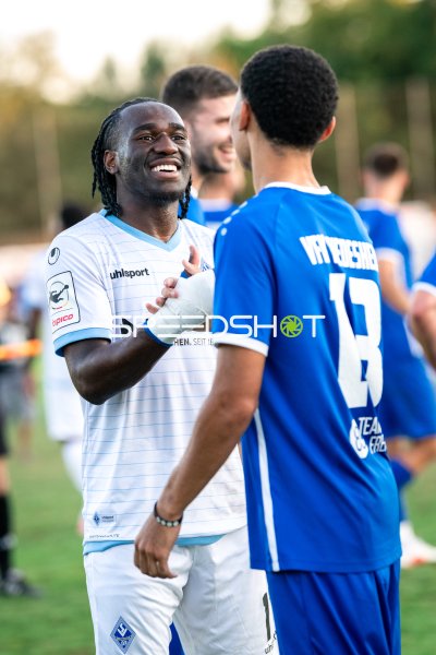 SV Waldhof Mannheim Spieler lacht mit VfK Diedesheim Gegenspieler nach dem Spiel
