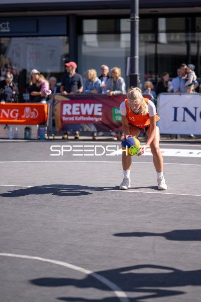 3x3-Basketball-Spielerin nimmt Ball auf dem Outdoor-Court in Hanau