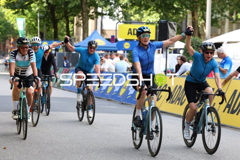 Jubelnde Hobbyfahrer überqueren die Ziellinie bei den Cyclassics Hamburg