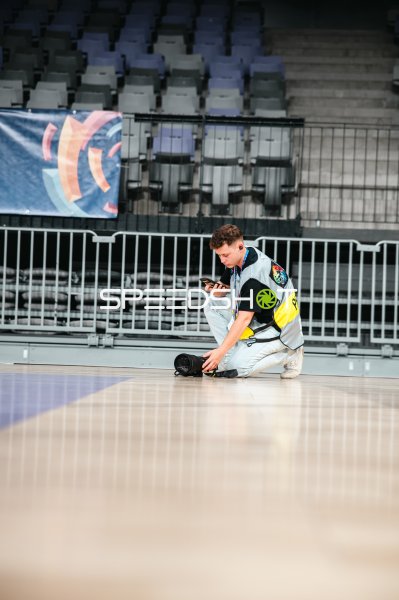 Fotograf mit Kamera und Smartphone auf dem Hallenboden der Pitesti Arena