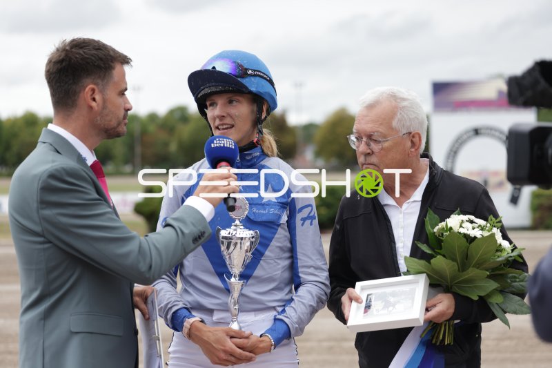 Siegerin im Interview: Jockeyin mit Pokal bei der Siegerehrung