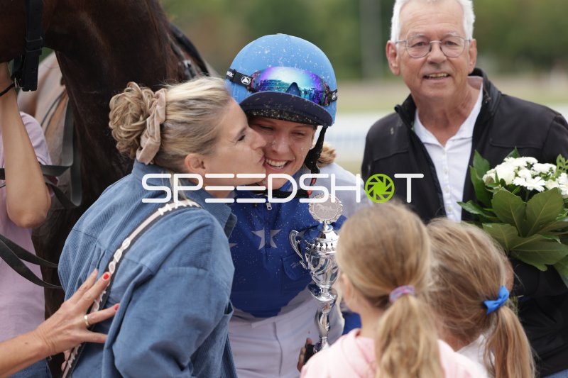 Siegerjubel: Jockey nach dem Rennen mit Pokal und Glückwunschkuss