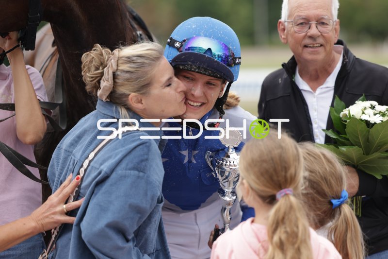 Jockey-Siegerin mit Pokal bei emotionaler Gratulation auf der Rennbahn Mariendorf