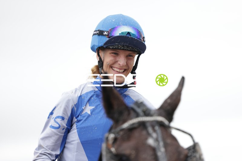 Jockeyrin strahlt nach dem Rennen auf der Rennbahn Berlin Mariendorf
