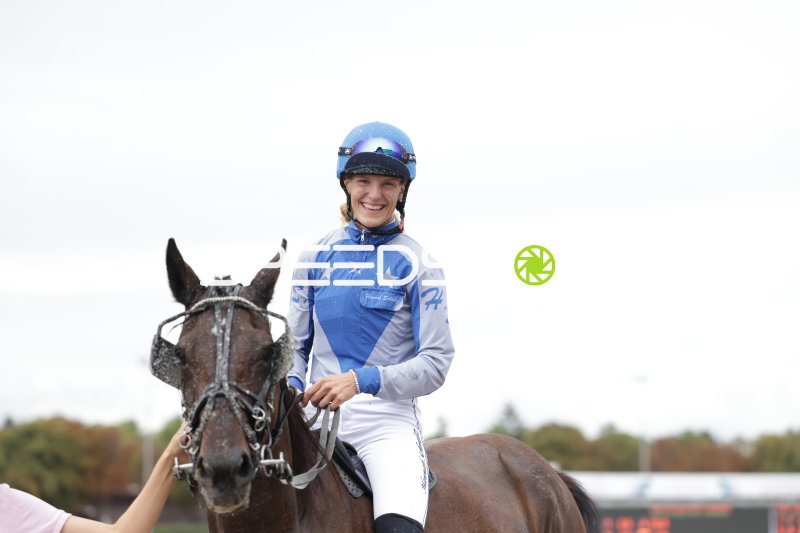 Jockeyrin lächelt nach dem Rennen auf der Rennbahn Berlin Mariendorf