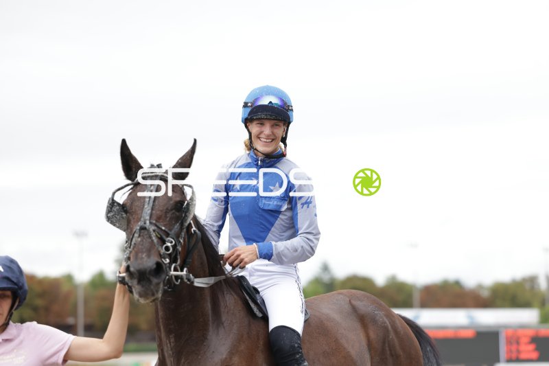 Jockey nach dem Rennen strahlend auf dem Pferd in Mariendorf