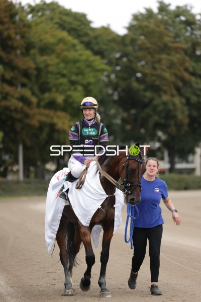 Jockey auf Siegerpferd mit Begleiterin auf der Rennbahn Mariendorf