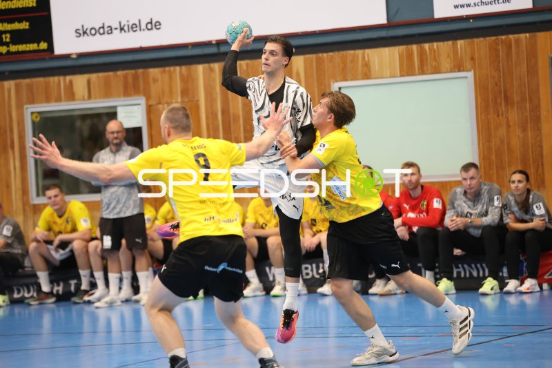 Domen Makuc (#35; THW Kiel) springt zum Wurf zwischen zwei Altenholz-Abwehrspielern