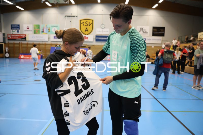 Rune Dahmke (#23; THW Kiel) signiert sein Trikot für einen Fan