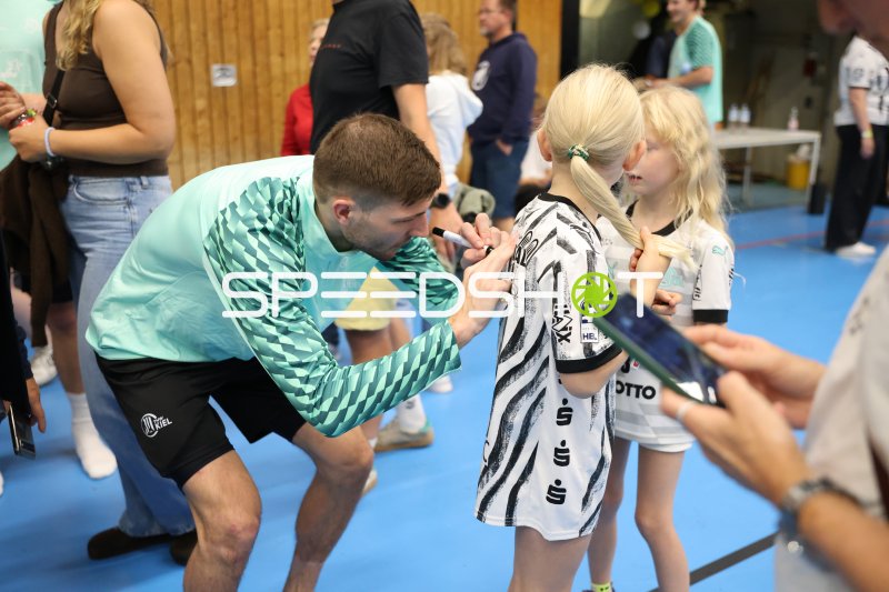 THW-Kiel-Spieler gibt Autogramm an junge Fans in der Edgar Meschkat Halle