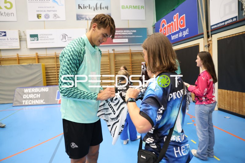 THW Kiel Spieler gibt Autogramm für Fan in der Edgar Meschkat Halle