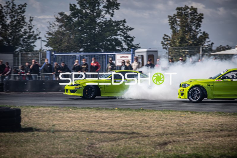 Zwei neongrüne Drift-Fahrzeuge im Tandem mit massiver Reifenrauchentwicklung in Oschersleben
