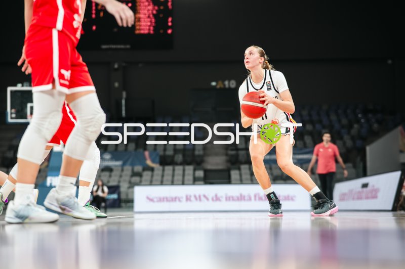 Basketballspielerin im Angriff mit Ball in der Pitesti Arena
